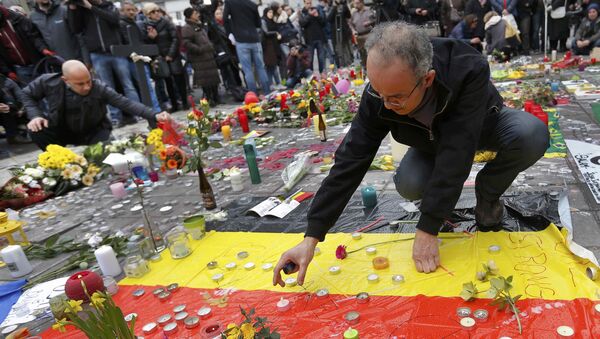 Men place a candles on a street memorial following Tuesday's bomb attacks in Brussels, Belgium, March 23, 2016 - Sputnik International