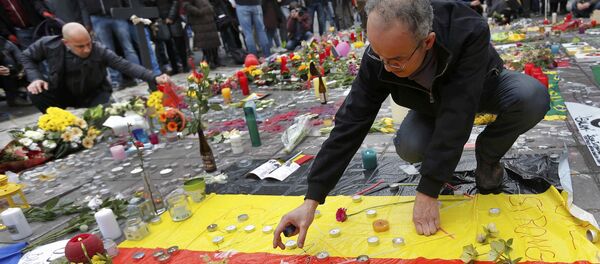 Men place a candles on a street memorial following Tuesday's bomb attacks in Brussels, Belgium, March 23, 2016 - Sputnik International