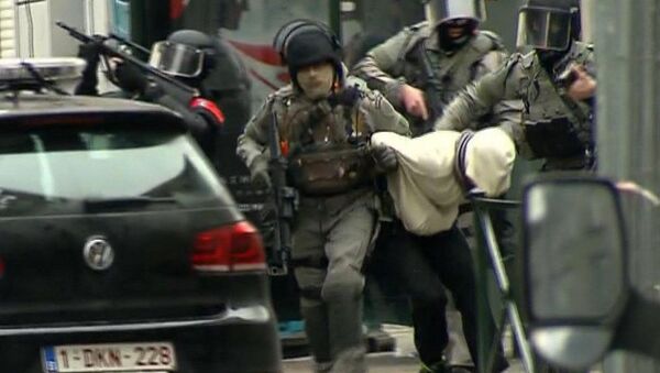 In this framegrab taken from VTM, armed police officers escort Salah Abdeslam to a police vehicle during a raid in the Molenbeek neighborhood of Brussels, Belgium, Friday March 18, 2016 - Sputnik International