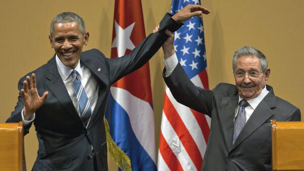 Cuban President Raul Castro, right, lifts up the arm of President Barack Obama at the conclusion of their joint news conference at the Palace of the Revolution, Monday, March 21, 2016, in Havana, Cuba - Sputnik International