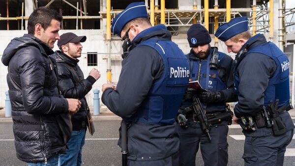 Police officers check the pasports of two men as they try to cross the French-Belgian border in Adinkerke, Belgium, on Wednesday, Feb. 24, 2016 - Sputnik International