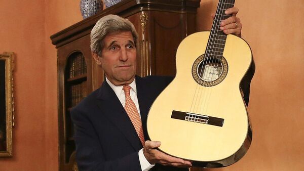 US Secretary of State John Kerry shows at the guitar which was given by Spanish Minister of Foreign Affairs and Cooperation Jose Manuel Garcia Margallo during a meeting in Madrid on October 18, 2015 - Sputnik International