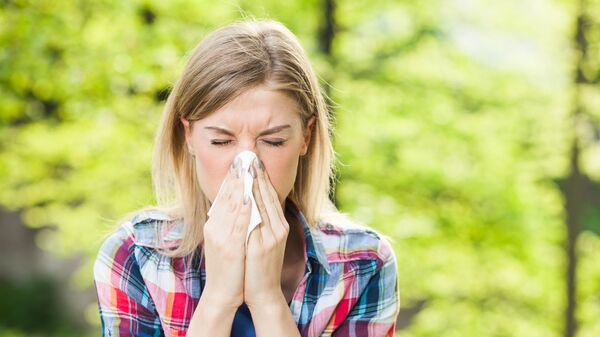 Woman with allergy symptom blowing nose. - Sputnik International