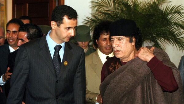 In this March 22, 2005 file photo, Syrian President Bashar Assad, left, talks to Libyan leader Moammar Gadhafi prior the 17th League of Arab States' summit in Algiers, Algeria. - Sputnik International