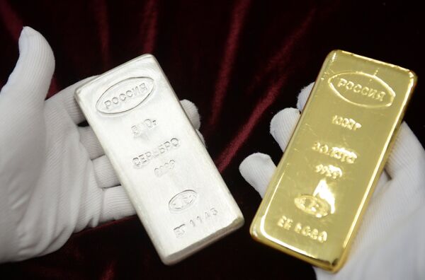A worker holds a gold bar and a silver bar produced during the opening of a new bank bar manufacturing line at a plant in Yekaterinburg. A worker holds a gold bar and a silver bar produced during the opening of a new bank bar manufacturing line at a plant in Yekaterinburg. - Sputnik International