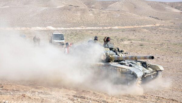 Forces loyal to Syria's President Bashar al-Assad drive a tank during their offensive to recapture the historic city of Palmyra in this picture provided by SANA on March 24, 2016. - Sputnik International
