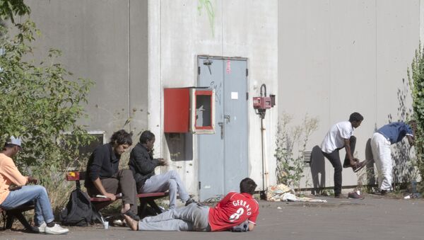 Migrants rest in the grounds of the Guillaume-Bude secondary school building in Paris. (File) - Sputnik International