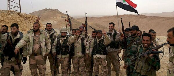 Forces loyal to Syria's President Bashar al-Assad flash victory signs and carry a Syrian national flag on the edge of the historic city of Palmyra in Homs Governorate, in this handout picture provided by SANA on March 26, 2016. - Sputnik International