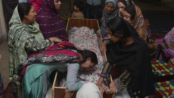 Pakistani relatives mourn over the body of a victim during a funeral following an overnight suicide bombing in Lahore on March 28, 2016 - Sputnik International