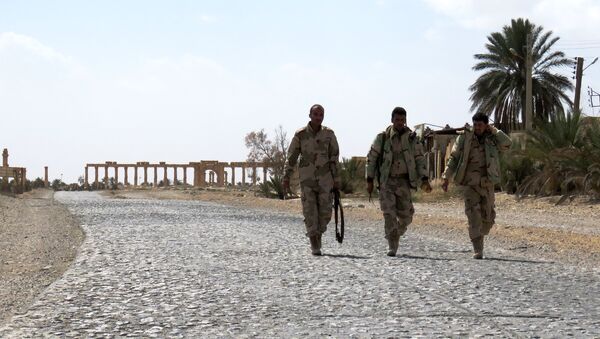 Syrian troops walk in the ancient city of Palmyra after they recaptured the site from the Islamic State (IS) group on March 27, 2016 - Sputnik International