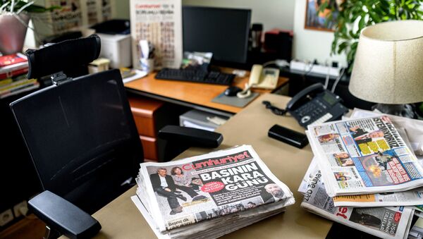 A picture taken on November 27, 2015 in Istanbul, shows newspapers at the office of Cumhuriyet Daily newspaper's Editor in Chief Can Dundar, as people demonstrate outside the headquarters after the arrest of Dundar. - Sputnik International
