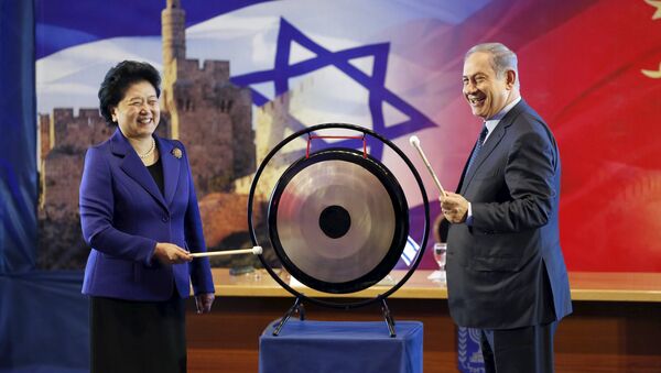 Israeli Prime Minister Benjamin Netanyahu (R) and Chinese Vice Premier Liu Yandong strike a gong during their joint news conference in Jerusalem March 29, 2016 - Sputnik International