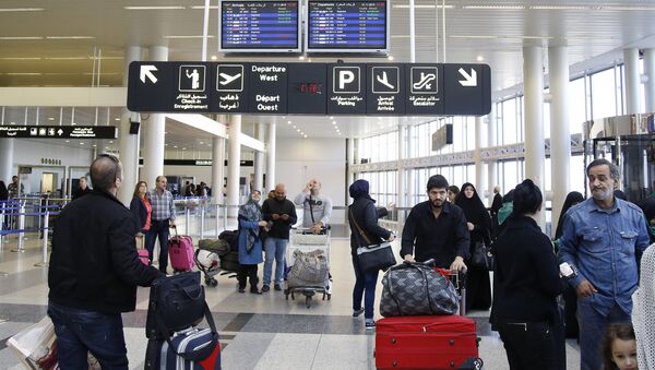 Travelers check the flight schedule screens for delays or cancellations, at the departure terminal of Rafik Hariri international airport in the Lebanese capital, Beirut, on November 21, 2015 - Sputnik International