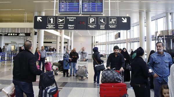 Travelers check the flight schedule screens for delays or cancellations, at the departure terminal of Rafik Hariri international airport in the Lebanese capital, Beirut, on November 21, 2015 - Sputnik International