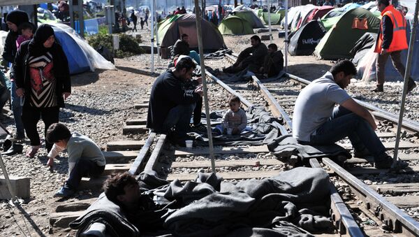 Migrants and refugees block the railway tracks as they protest in makeshift camp at the Greek-Macedonian border, near the Greek village of Idomeni on March 30, 2016, where thousands of them are stranded by the Balkan border blockade - Sputnik International
