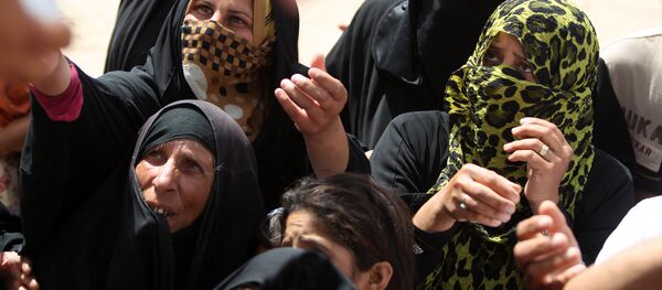 Displaced Iraqi women, who fled Ramadi, the capital of Anbar province, after it was seized by the Islamic State (IS) group, wait to get aid boxes at a makeshift camp for internally displaced persons (IDP) in Ameriyat al-Fallujah, 30 km south of Fallujah on June 6, 2015 Displaced Iraqi women, who fled Ramadi, the capital of Anbar province, after it was seized by the Islamic State (IS) group, wait to get aid boxes at a makeshift camp for internally displaced persons (IDP) in Ameriyat al-Fallujah, 30 km south of Fallujah on June 6, 2015 - Sputnik International