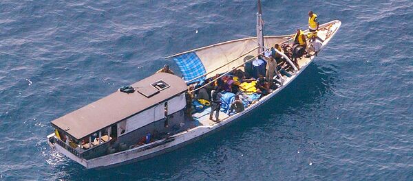 Turkish Kurd refugees on an Indonesian fishing boat are guarded by Navy personnel 20 kms off Melville Island, near the northern mainland city of Darwin. The fate of the refugees suspected to be seeking asylum in Australia was unknown after they sailed into a legal storm over the country's tough immigration laws (File) - Sputnik International