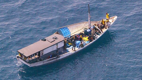 Turkish Kurd refugees on an Indonesian fishing boat are guarded by Navy personnel 20 kms off Melville Island, near the northern mainland city of Darwin. The fate of the refugees suspected to be seeking asylum in Australia was unknown after they sailed into a legal storm over the country's tough immigration laws - Sputnik International