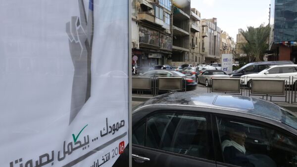 Syrians drive past a billboard for the upcoming parliamentary elections in the capital Damascus on March 15, 2016 - Sputnik International