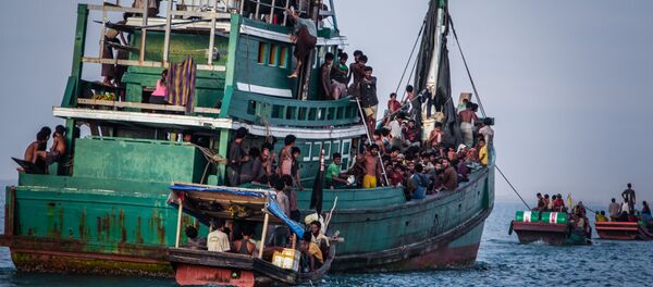 In this photo taken on May 20, 2015 shows Rohingya migrants resting on a boat off the coast near Kuala Simpang Tiga in Indonesia's East Aceh district of Aceh province before being rescued. Indonesia's foreign minister demanded answers from Canberra about claims Australian officials paid thousands of dollars to turn a boat back to Indonesia after Prime Minister Tony Abbott refused to deny the allegations - Sputnik International