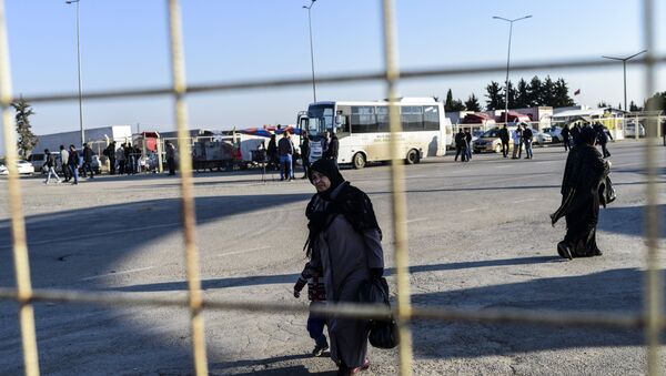 A Syrian woman and a child walks back towards the Syrian crossing, on February 8, 2016 at Turkish Oncupinar border gate near Kilis, southern-central Turkey - Sputnik International