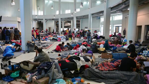 Migrants and refugees rest at the passengers terminal at the port of Piraeus where more than 5,500 migrants and refugees have found temporary shelter on March 30, 2016 - Sputnik International