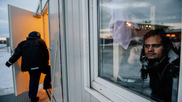 A refugee looks through a window at the arrival centre for refugees near the town on Kirkenes in northern Norway - Sputnik International