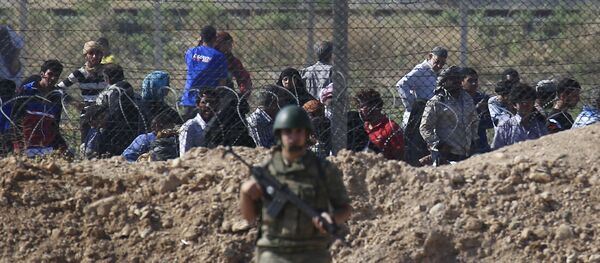File photo of a Turkish army soldier guards the border area with Syria as in the background Syrian refugees wait in Syria in order to cross into Turkey, in Akcakale, southeastern Turkey, Monday, June 15, 2015 File photo of a Turkish army soldier guards the border area with Syria as in the background Syrian refugees wait in Syria in order to cross into Turkey, in Akcakale, southeastern Turkey, Monday, June 15, 2015 - Sputnik International