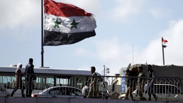 People walk near a Syrian national flag at the President bridge in Damascus, Syria March 14, 2016 - Sputnik International