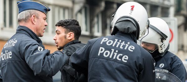 Policemen detain a man in the Molenbeek neighborhood in Brussels, Belgium - Sputnik International