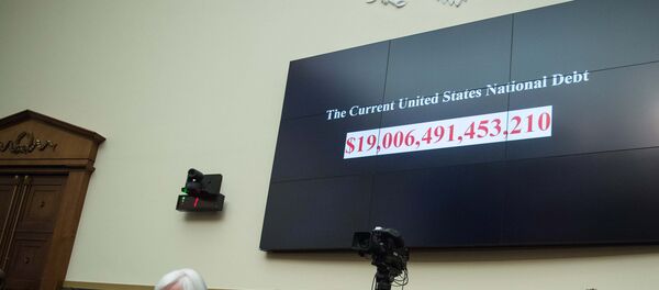 A screen shows the US national debt before US Federal Reserve chair Janet Yellen (front L) testifies before the House Financial Services Committee on Capitol Hill in Washington, DC, on February 10, 2016. - Sputnik International