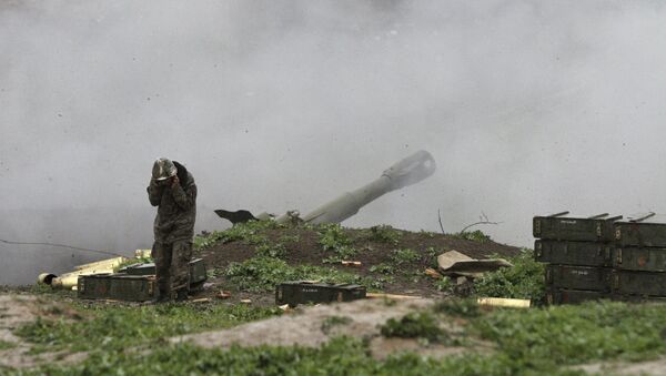 An Armenian serviceman of the self-defense army of Nagorno-Karabakh launch artillery toward Azeri forces in the town of Martakert in Nagorno-Karabakh region - Sputnik International