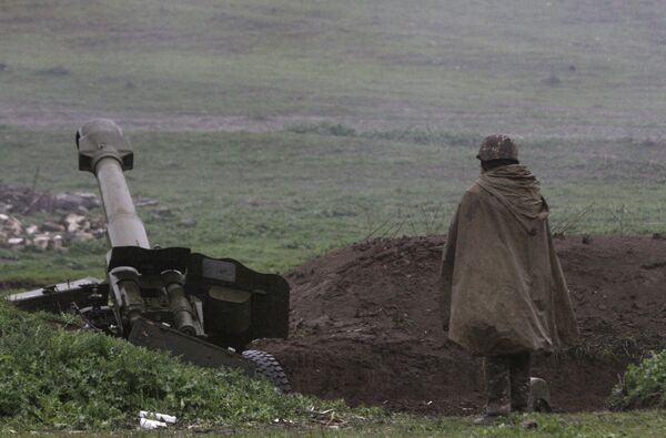 An Armenian soldier of the self-defense army of Nagorno-Karabakh stands near an artillery unit in the town of Martakert, where clashes with Azeri forces are taking place, in Nagorno-Karabakh region - Sputnik International