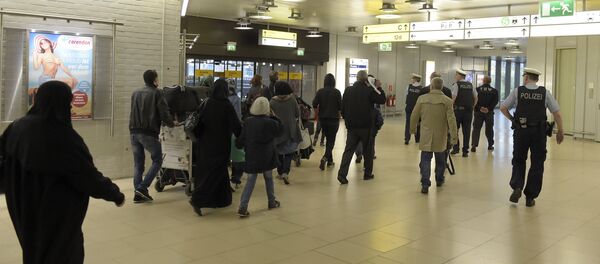 Policemen escort a group of refugees after their arrival at the airport in Hanover, central Germany, on April 4, 2016. Policemen escort a group of refugees after their arrival at the airport in Hanover, central Germany, on April 4, 2016. - Sputnik International