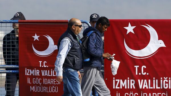 A migrant is escorted by a Turkish police officer as he arrives in the Turkish coastal town of Dikili, Turkey, April 4, 2016 - Sputnik International