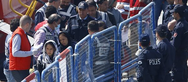 Migrants are escorted by Turkish police officers as they arrive in the Turkish coastal town of Dikili, Turkey, April 4, 2016. Migrants are escorted by Turkish police officers as they arrive in the Turkish coastal town of Dikili, Turkey, April 4, 2016. - Sputnik International