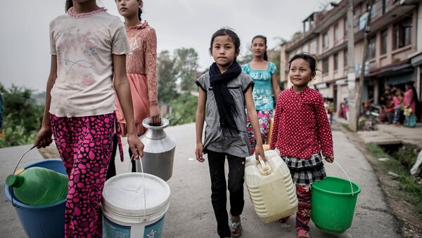 Children carry buckets to get water distributed as relief aid outside Bungamati village, in the outskirts of Kathmandu on May 8, 2015. - Sputnik International