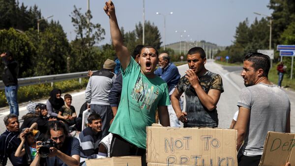Migrants and refugees shout slogans as they block the highway near the Greek-Macedonian border near the village of Evzoni, Greece, April 4, 2016. - Sputnik International