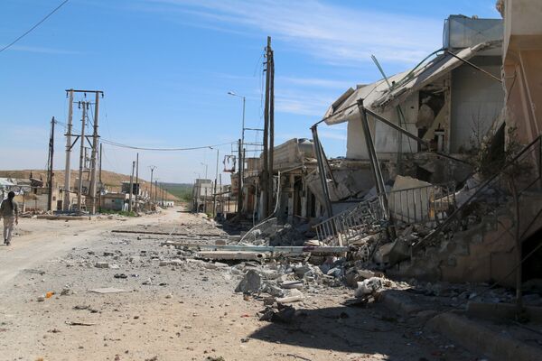 A man walks near damaged houses after Syrian rebels and the al Qaeda-affiliated Nusra Front took control of al-'Iss town, in Aleppo countryside, Syria April 2, 2016. A man walks near damaged houses after Syrian rebels and the al Qaeda-affiliated Nusra Front took control of al-'Iss town, in Aleppo countryside, Syria April 2, 2016. - Sputnik International