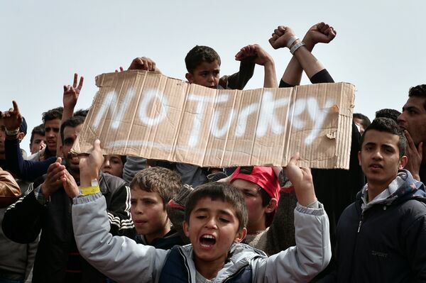 Refugees and migrants including children who left the Chios registration camp, shout slogans and hold placards reading 'No Turkey during a protest on April 3, 2016 as they camp out in the port of Chios. Refugees and migrants including children who left the Chios registration camp, shout slogans and hold placards reading 'No Turkey during a protest on April 3, 2016 as they camp out in the port of Chios. - Sputnik International