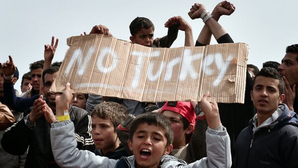 Refugees and migrants including children who left the Chios registration camp, shout slogans and hold placards reading 'No Turkey during a protest on April 3, 2016 as they camp out in the port of Chios. - Sputnik International