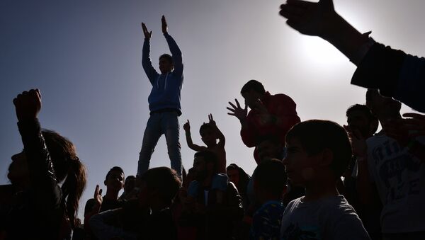 The silhouettes of Kurdish refugees who managed to leave the VIAL detention center on the island of Chios are seen as they protest against deportations to Turkey at the island's port where they are camping out on April 5, 2016. - Sputnik International
