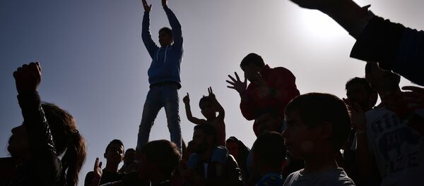 The silhouettes of Kurdish refugees who managed to leave the VIAL detention center on the island of Chios are seen as they protest against deportations to Turkey at the island's port where they are camping out on April 5, 2016. - Sputnik International