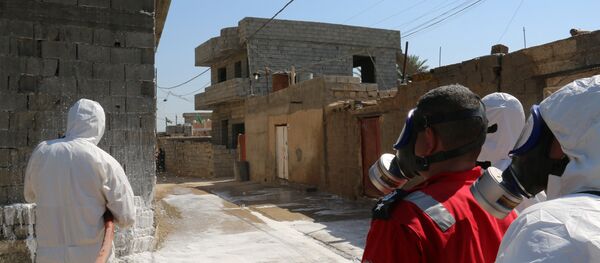 Members of the civil defence spray and clean areas in the town of Taza, around 220 kilometres north of the capital Baghdad, on March 13, 2016, that might have been contaminated in a chemical attack carried out by the Islamic State (IS) group the previous week - Sputnik International
