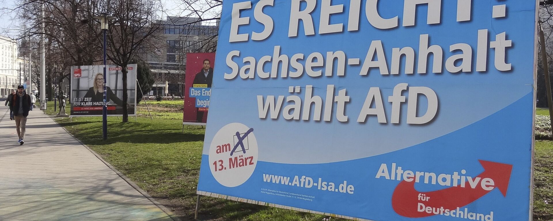 A man walks past a campaign poster of right-populist AfD party reading It's enough - Saxony-Anhalt elects AfD in Magdeburg, Germany. - Sputnik International, 1920, 03.05.2025