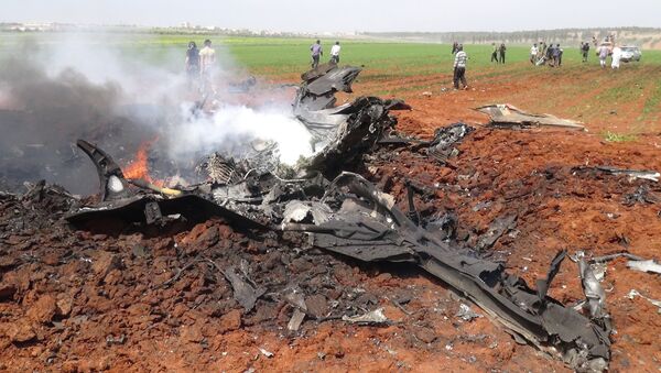 A general view shows the wreckage of a government warplane after Al-Nusra front (Al-Qaeda's Syria affiliate) reportedly shot it down over the northern Syrian town of Al-Eis on April 5, 2016 - Sputnik International