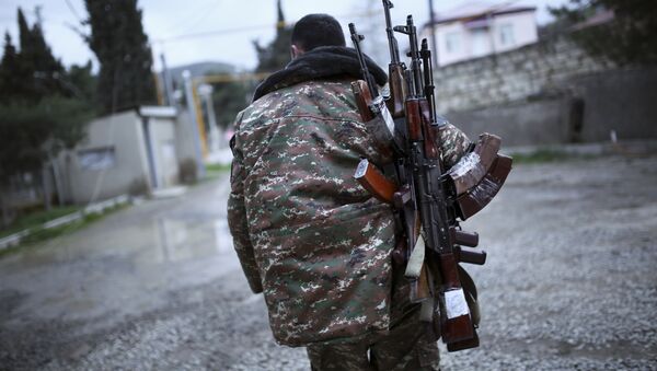 An ethnic Armenian fighter carries Kalashnikov machine guns to his comrade-in-arms at Martakert province in the separatist region of Nagorno-Karabakh, Azerbaijan, Monday, April 4, 2016 - Sputnik International