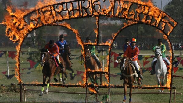 Nepalese soldiers on horseback jump through burning arches during the Ghode Jatra (horse race) festival in Kathmandu on April 3, 2011 - Sputnik International