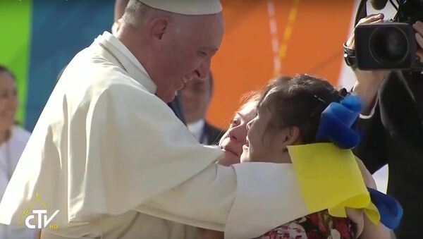 Pope Francis embracing two women with the Down Syndrome Awareness Ribbon. - Sputnik International