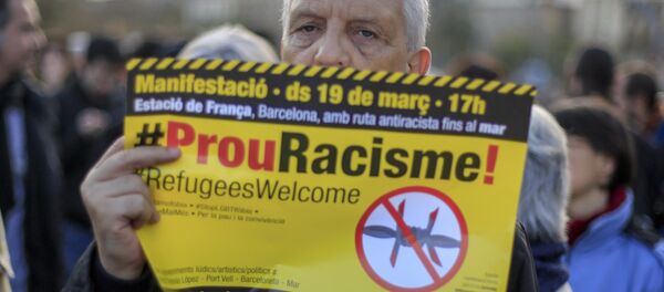 A protester called by Stop Mare Mortum and “Unity against Fascism and Racism” platforms, holds a poster reading Stop Racism in Catalan during the European March for Refugee Rights in Barcelona on March 19, 2016. - Sputnik International